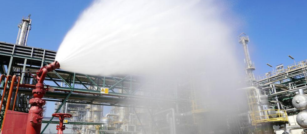 Canhão monitor industrial projetando jato de água em sistema de combate a incêndio
